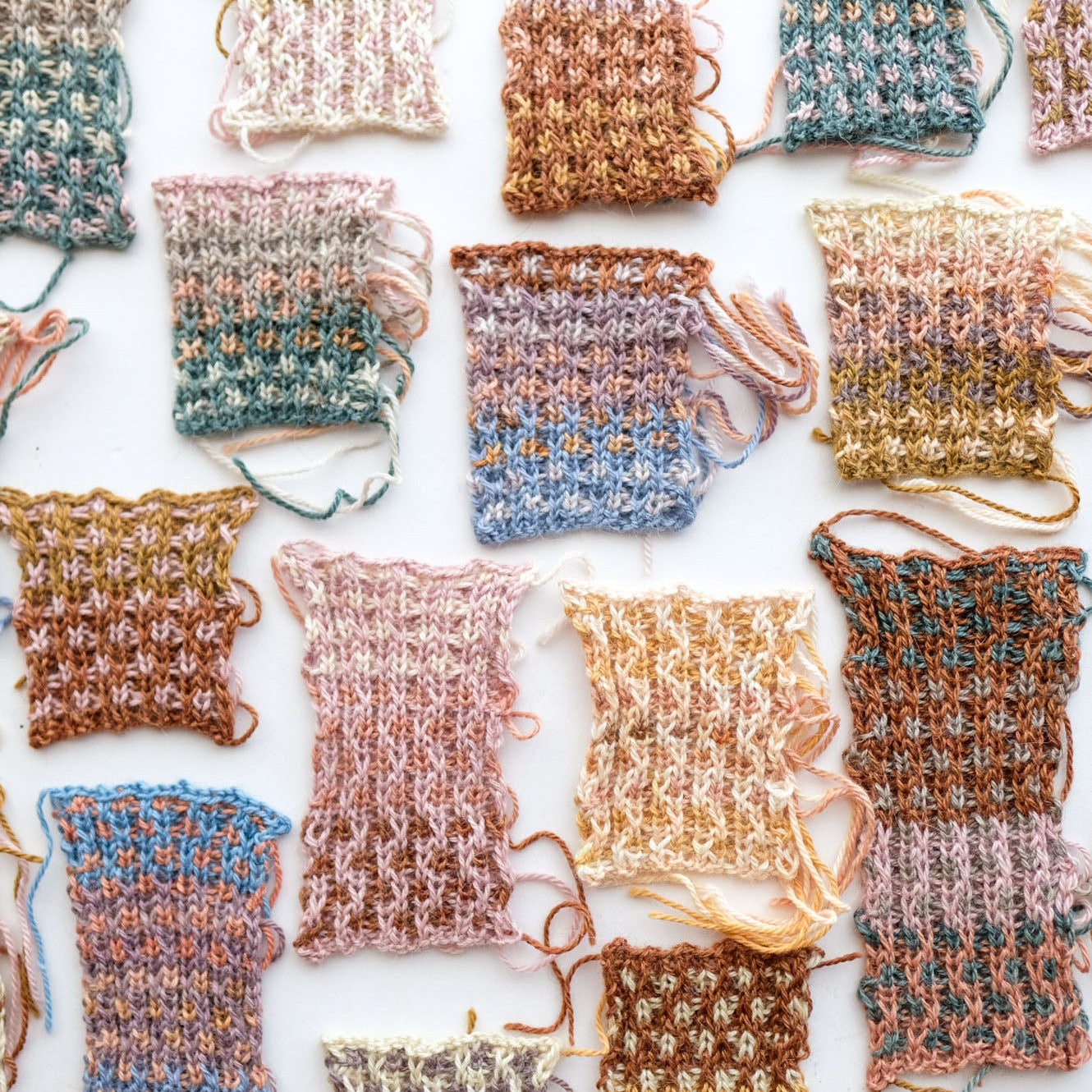Collection of small knitted swatches in various colors on a white background