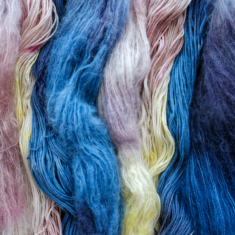 Close-up of colorful yarn with blue, pink, and yellow hues.
