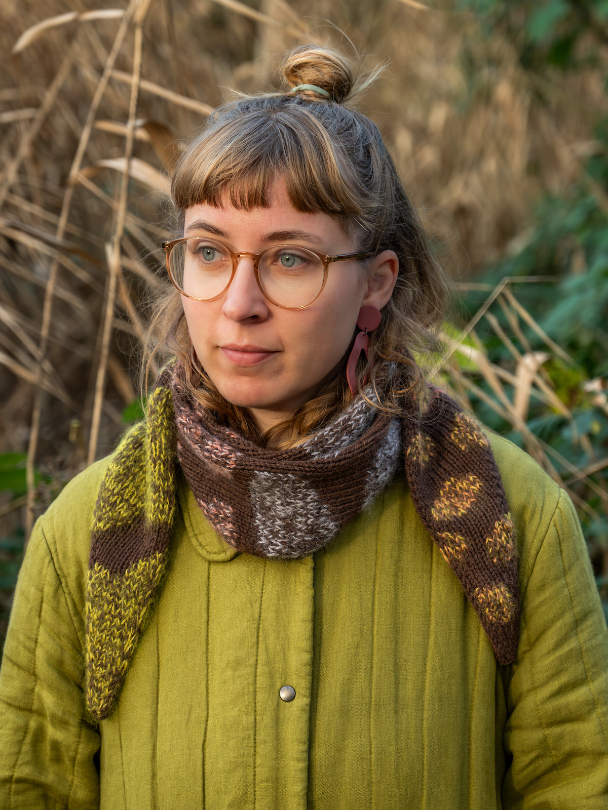 Person wearing a green coat and Shifting Moods Scarf tied in a stylish manner