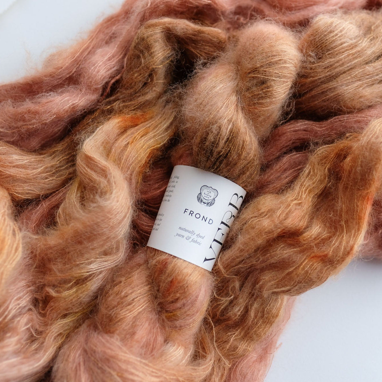 skein of pinkish-brown yarn with a label on a white background