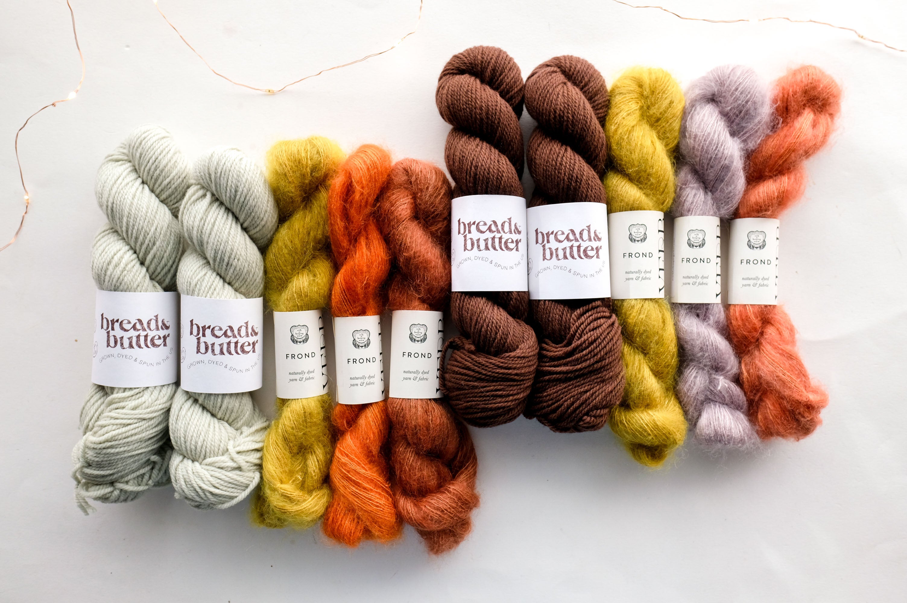 Set of colorful yarn skeins with visible labels on a white background
