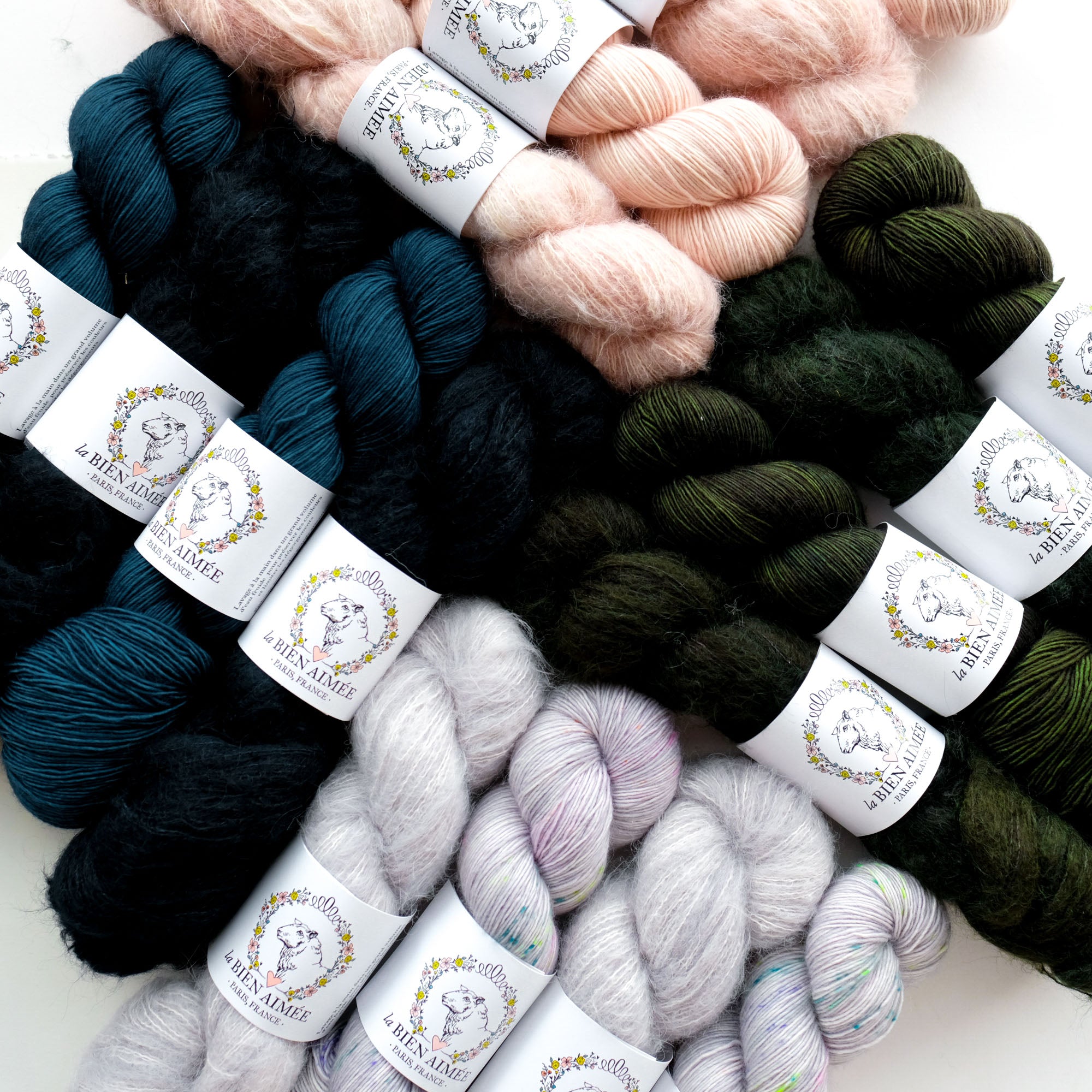 Assorted skeins of yarn in various colors with labels on a white background