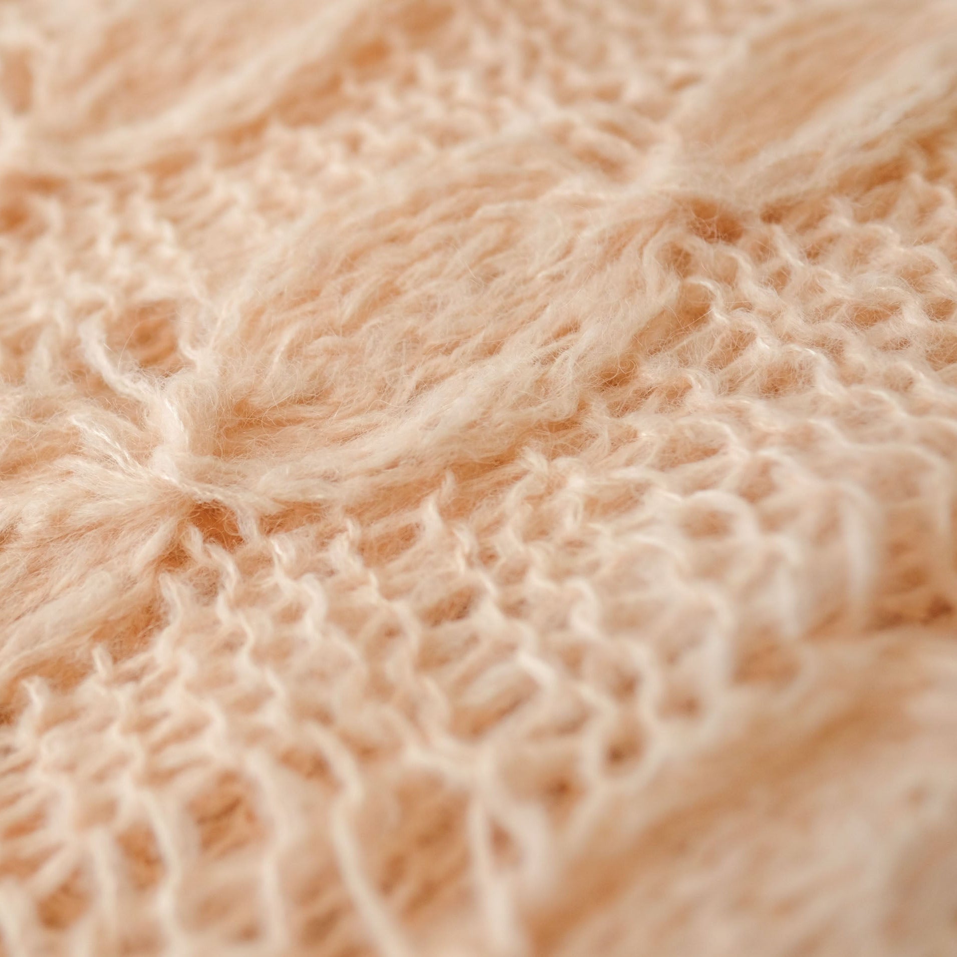 Close-up of a cabled peach handknit shawl 
